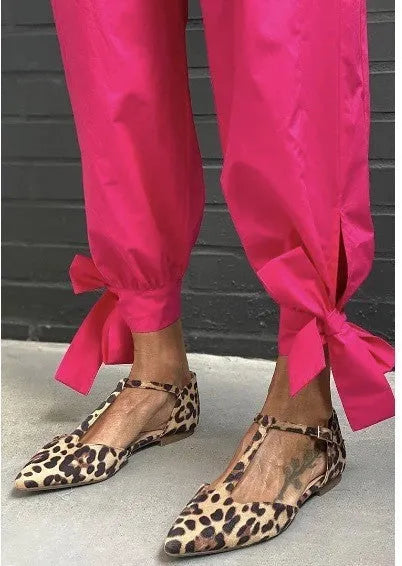 Leopard print women's pumps with a low chunky heel, pointed toe, and cross ankle straps.