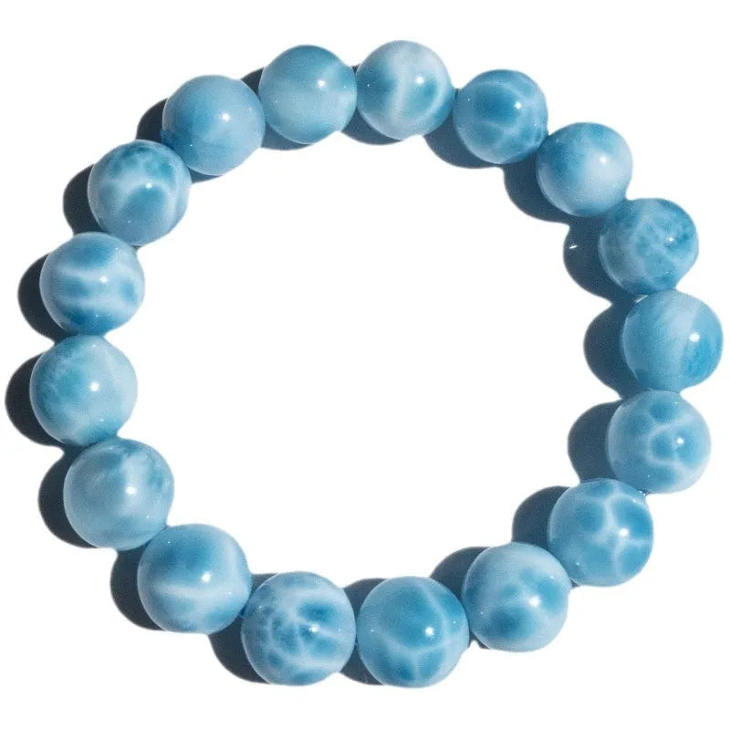 Blue natural Bodhi seed and crystal sea-pattern stone bracelet with a single pearl accent on a wrist.