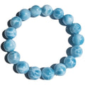 Blue natural Bodhi seed and crystal sea-pattern stone bracelet with a single pearl accent on a wrist.