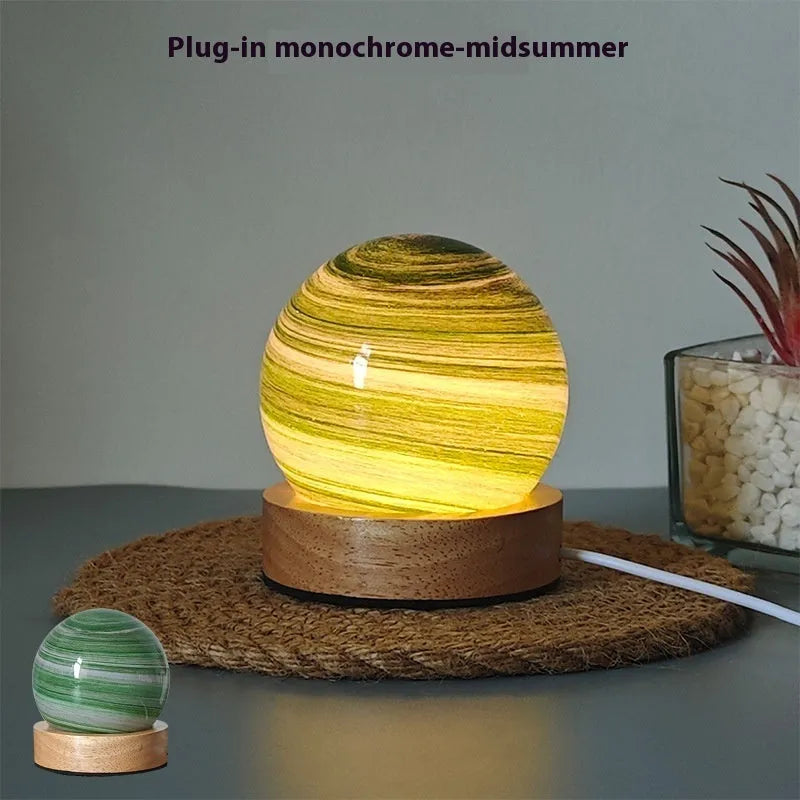Compact modern planet USB night light on its base with dimmable three-colour lighting.