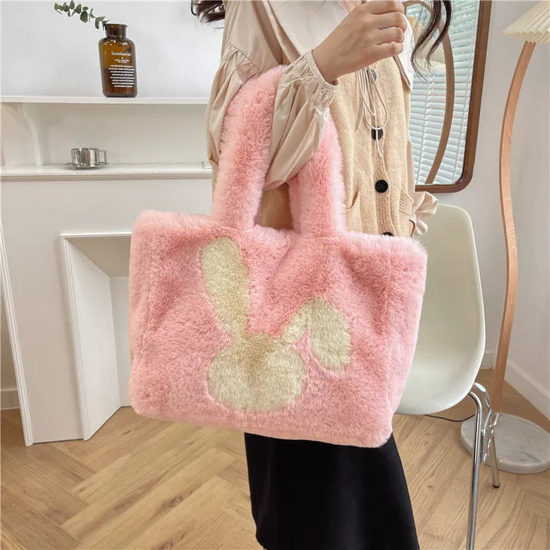Soft plush shoulder bag with cartoon rabbit ears in one of six solid colours.