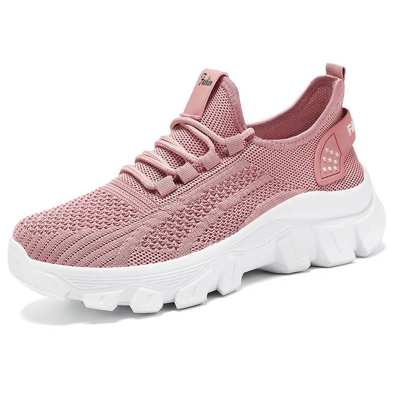 Women's white Flyknit sneaker with thick sole and lace-up front, shown on a neutral background
