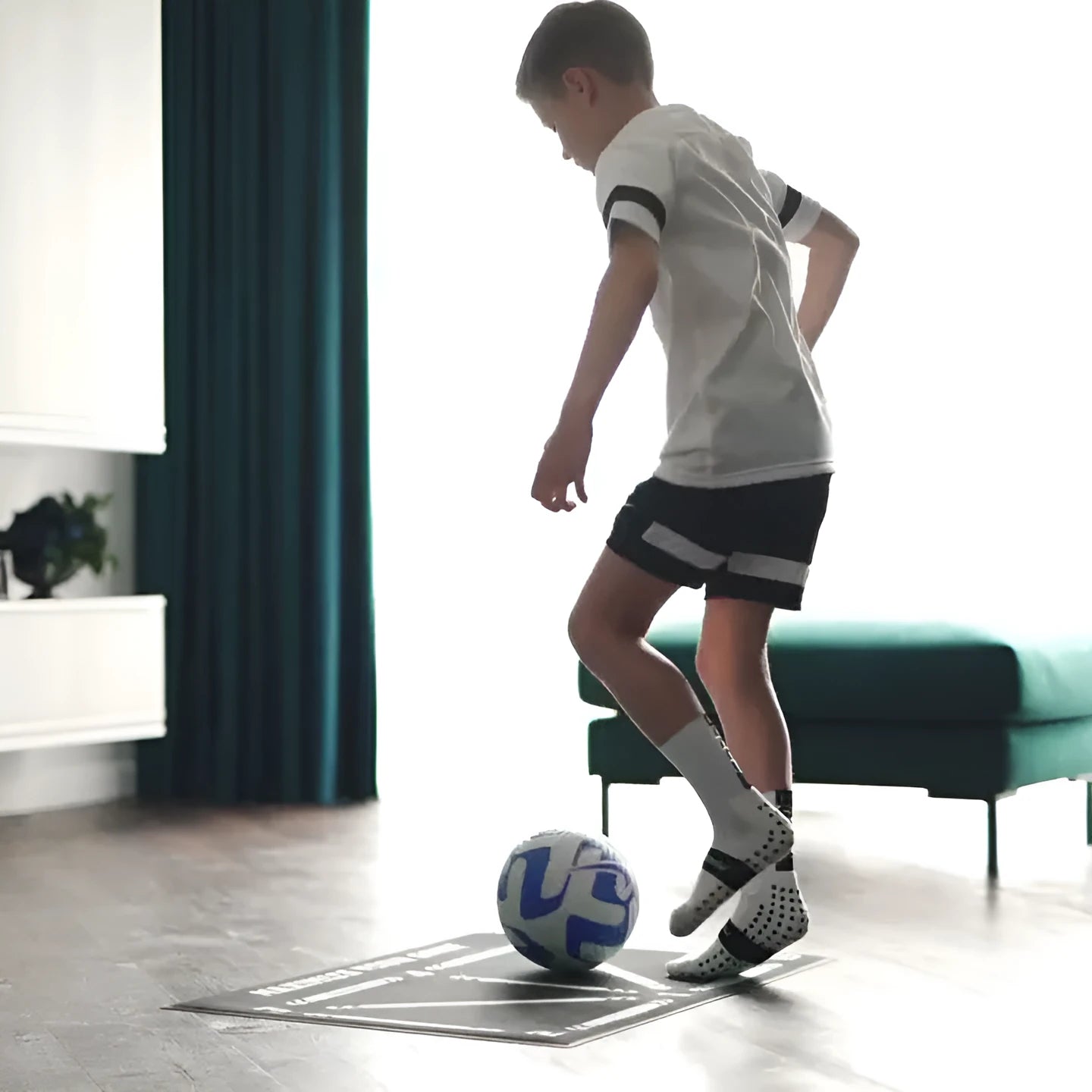 Black 60x90cm football training mat on a flat surface