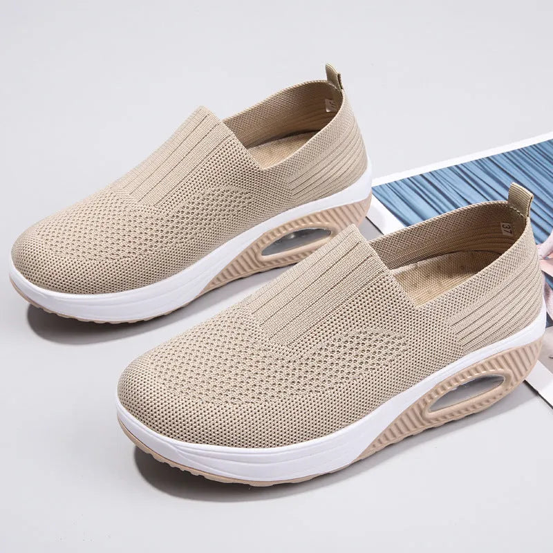 Women's mesh running shoes with air cushion midsole in beige colour on a white background.