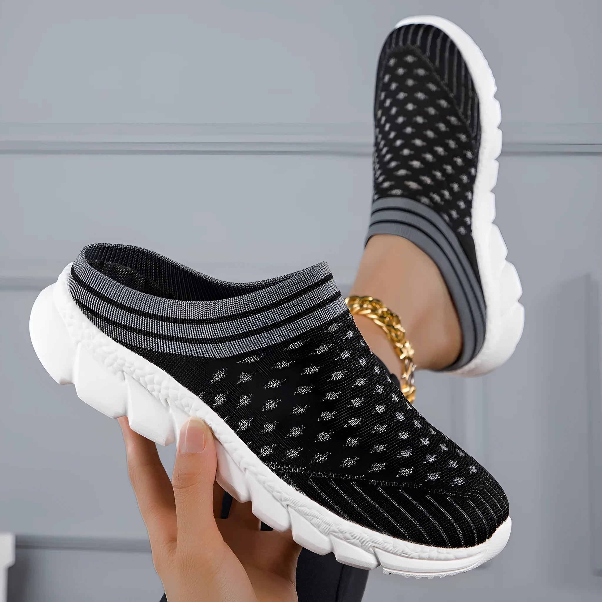 Women's black Flyknit slipper shoes with striped pattern and hollowed-out design on a viscose sole.