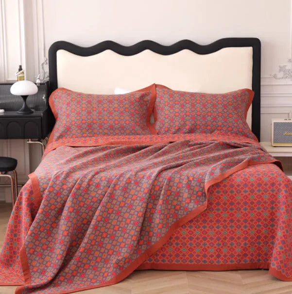 Three-piece cotton gauze bed blanket set with floral botanical pattern, shown with pillowcases.