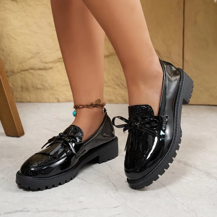 Women's brown and black loafer shoes with decorative bow detailing