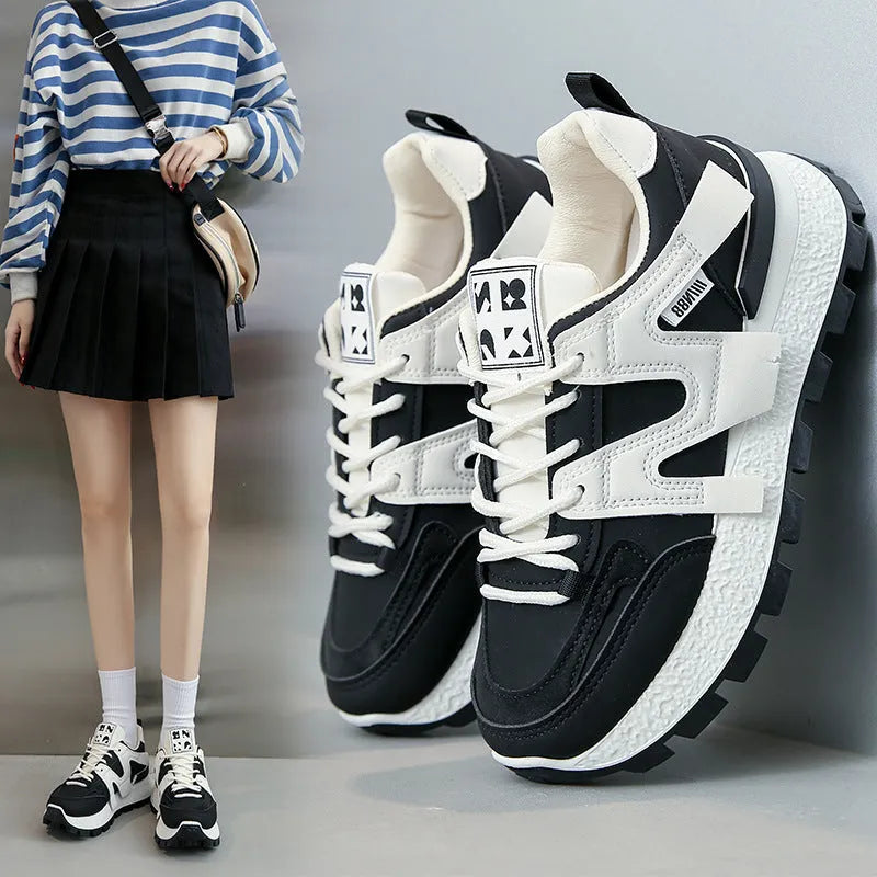 White and black unisex low-top sneakers with round toe and front lace-up on rubber sole