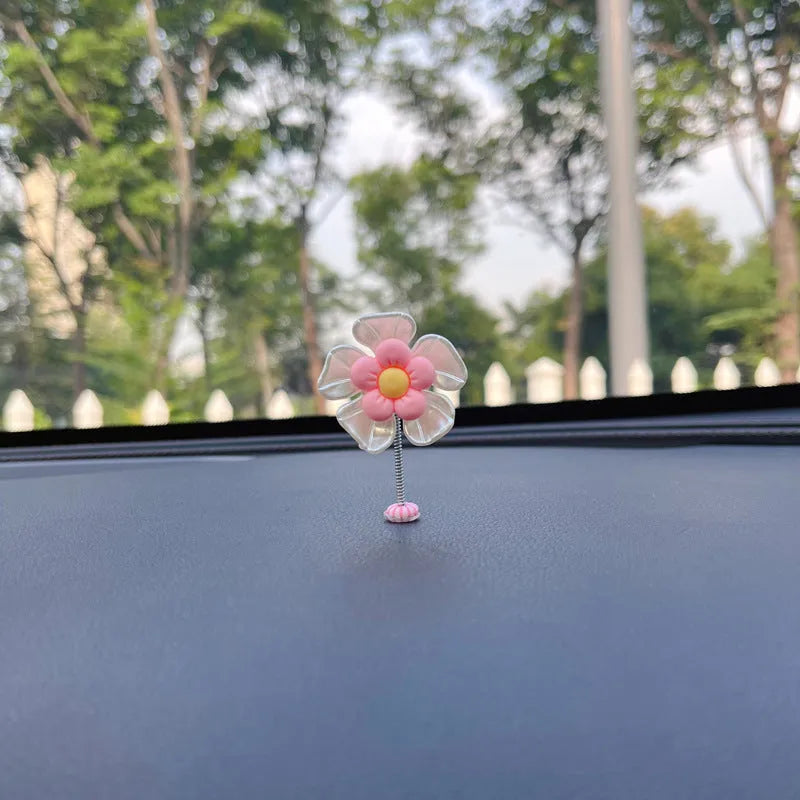 Small colourful plastic car swing decoration hanging from a rear-view mirror.