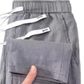 Man wearing apricot-coloured straight leg linen trousers with a drawstring waist.