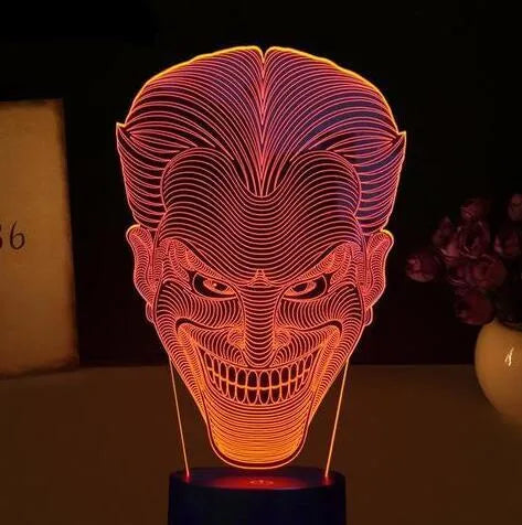 3D LED table lamp showing seven colour options with remote control and USB cable on wooden surface