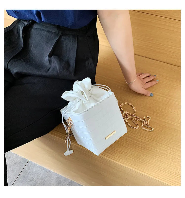 Small black PU leather women's chain messenger bucket bag with a single strap and zip opening.