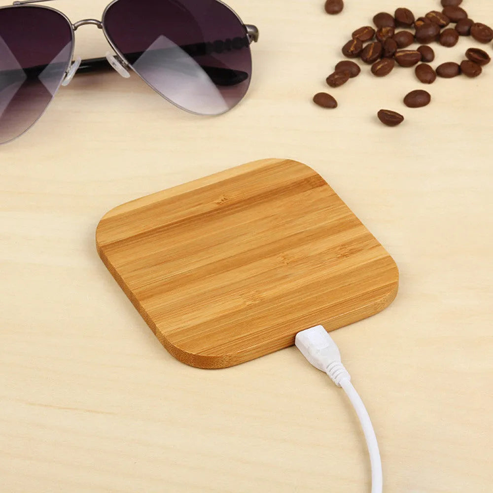 Square brown heart-shaped wooden bamboo 5W wireless charging pad on a table.