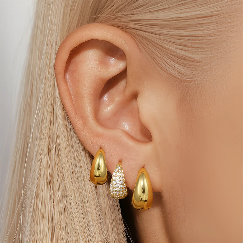 A pair of simple geometric brass earclip earrings with a round element and electroplated golden finish.