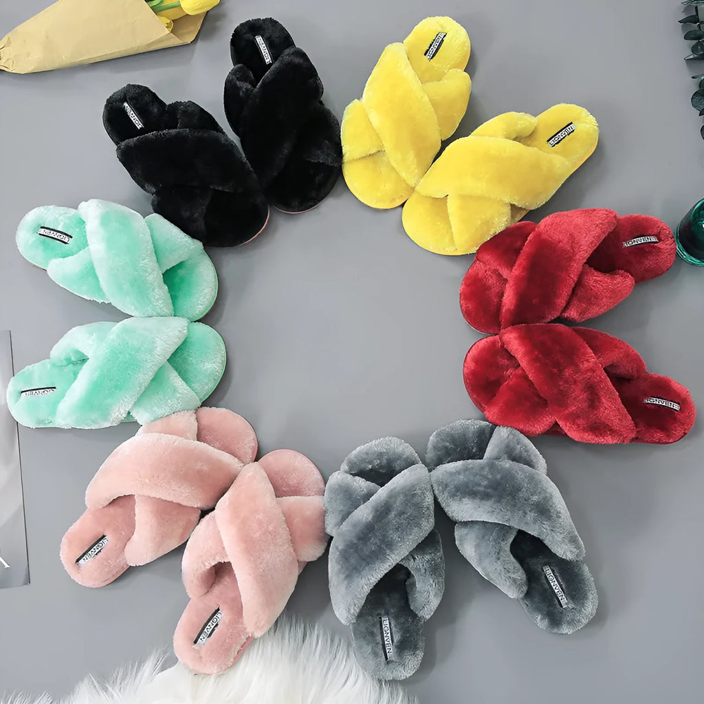 Women's black cross open-toe fur slippers with a patterned non-slip sole on a wooden floor