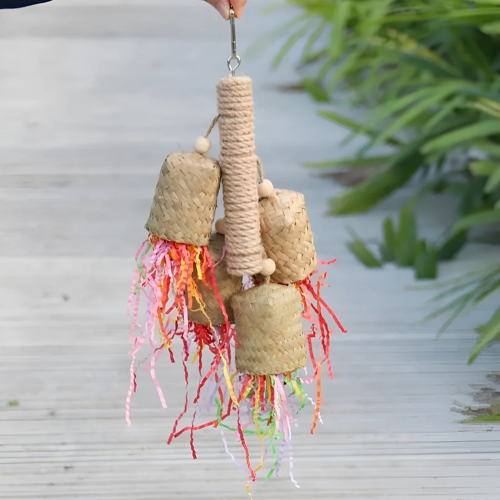 Wooden parrot chew toy with colourful shredded paper hanging from sisal rope