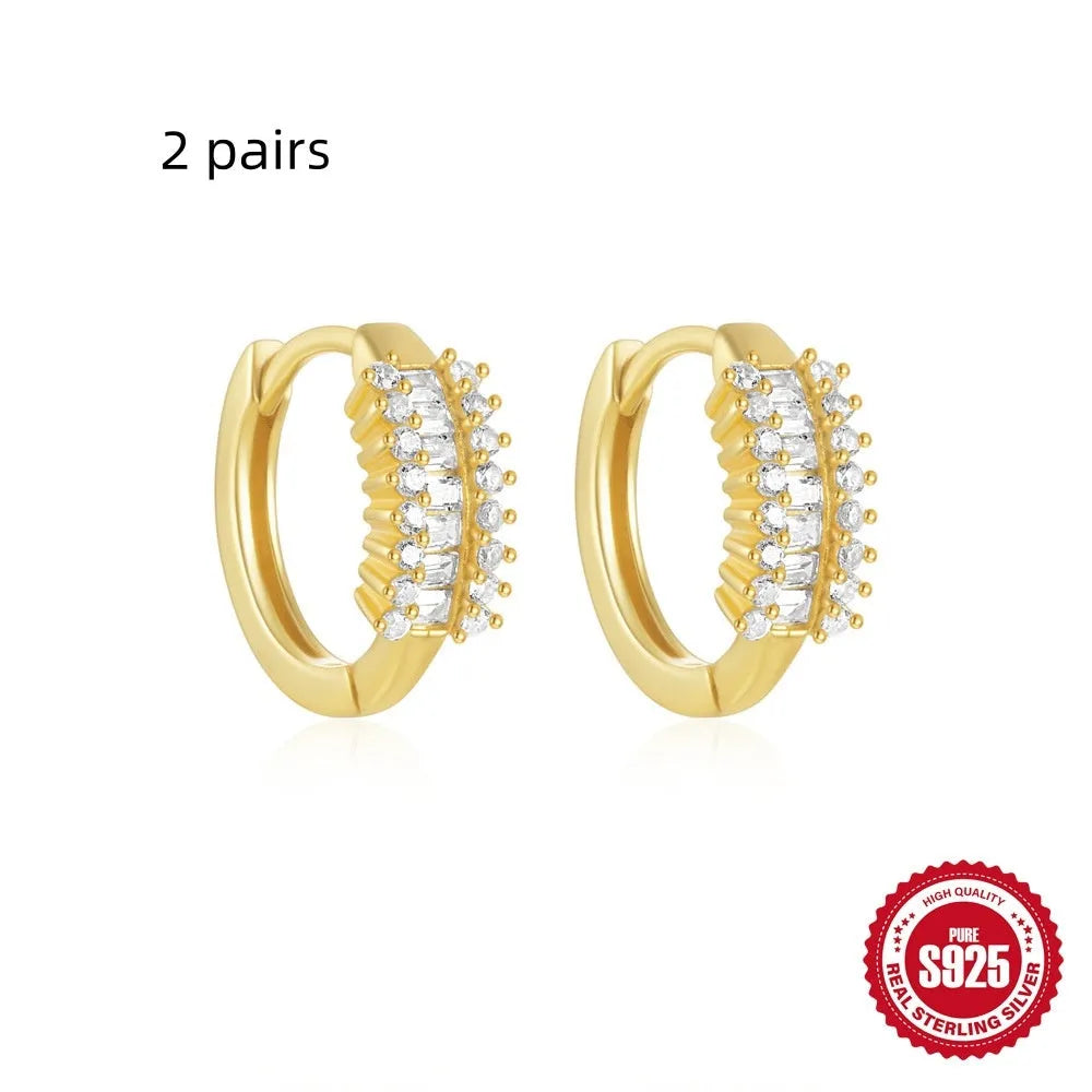 Sterling silver geometric stud earrings with a small round shape and classic diamond detail on a white background.