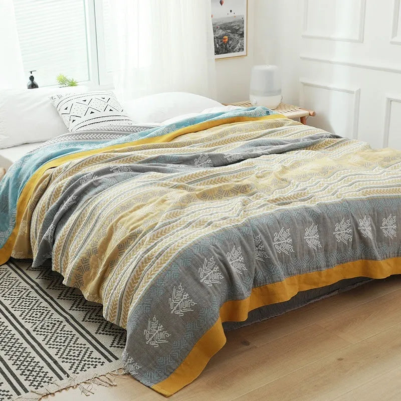 Blue five-layer gauze pure cotton blanket folded to show texture and modern printed pattern.