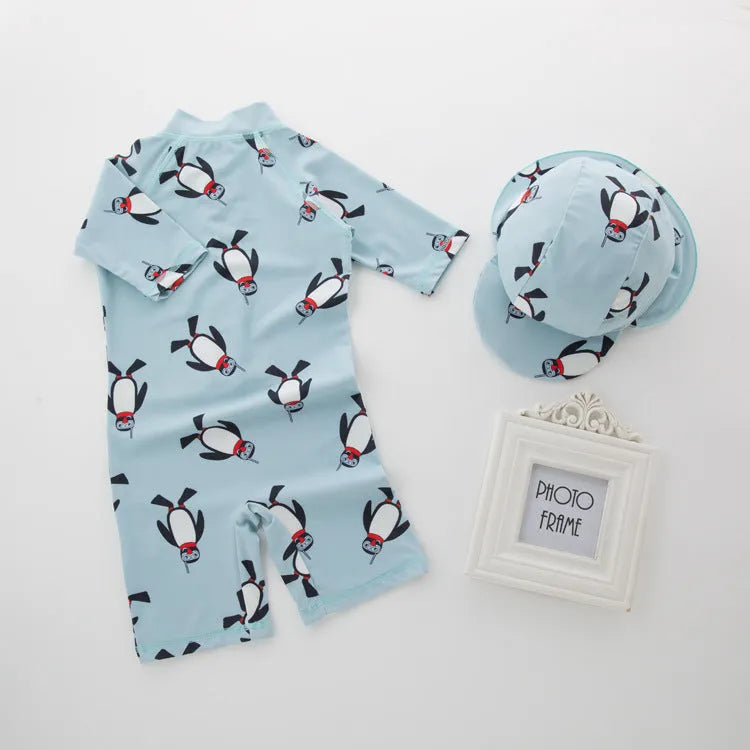Boys' penguin print long sleeve swim top and matching swimming cap set on a hanger.