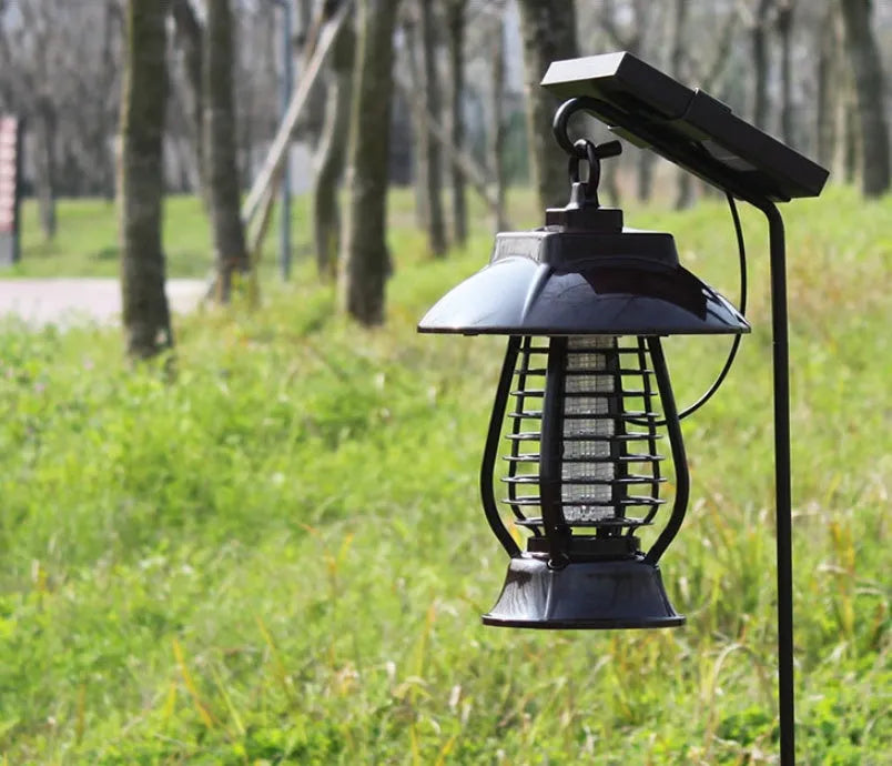 White outdoor solar mosquito lamp with purple switch and solar panel on top for garden insect control.