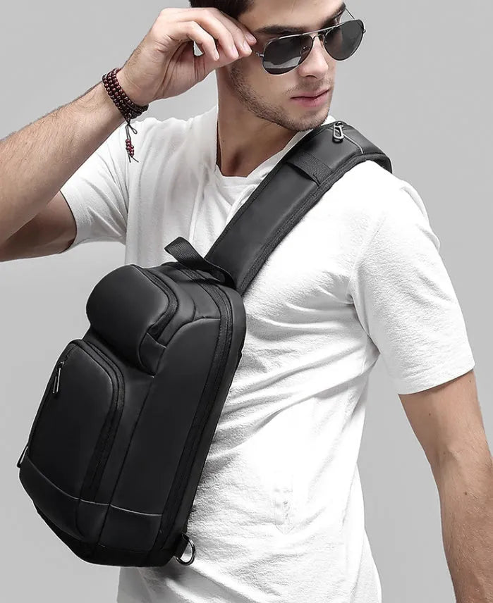Black outdoor shoulder bag showing internal computer pocket and air cushion shoulder strap