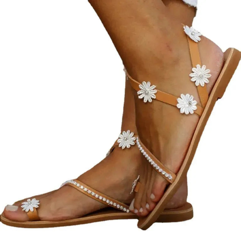 Brown women's flat sandals with floral pattern and herringbone toe on a rubber sole.