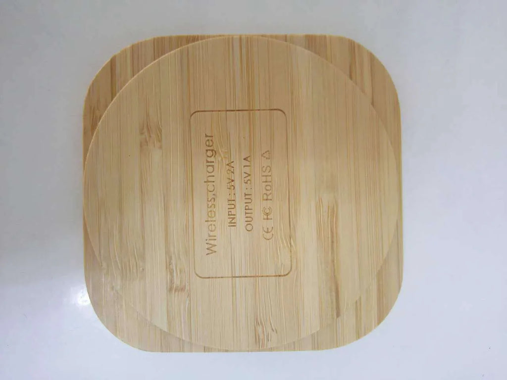 Square brown heart-shaped wooden bamboo 5W wireless charging pad on a table.