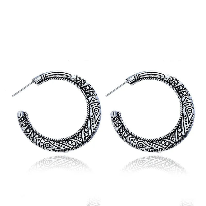 Vintage bronze C-shaped alloy earrings with a distressed engraved surface texture.