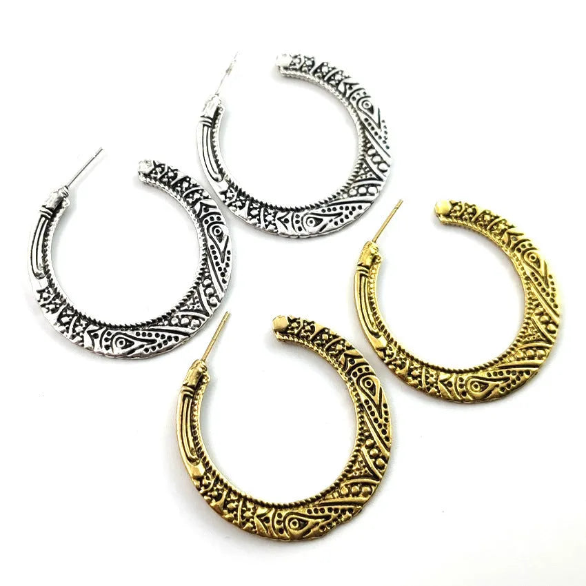 Vintage bronze C-shaped alloy earrings with a distressed engraved surface texture.