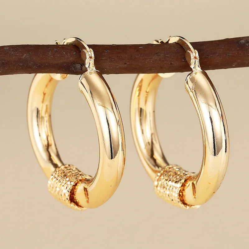 Geometric copper earrings with gold tone finish showing ring and line design elements