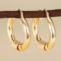 Geometric copper earrings with gold tone finish showing ring and line design elements