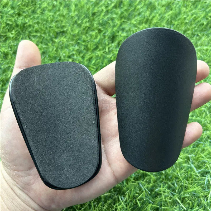 Extra small 8x5cm plastic football shin guards in black and white colours