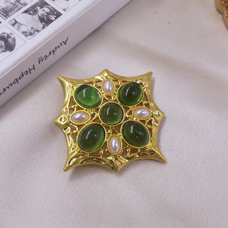 A vintage-style zinc alloy brooch with a baroque cross design and crystal accents.
