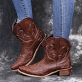 Blue women's cowboy boots with floral embroidery, a wedge heel, and a pointed toe.