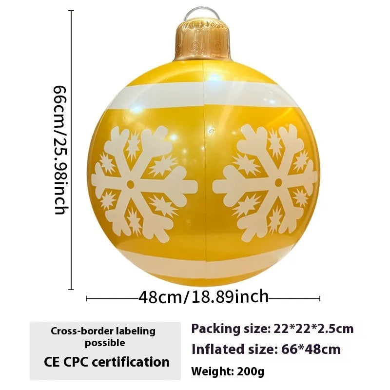 Large red inflatable Christmas ball with snowflake pattern and flash light, shown with a hand pump in a garden setting.