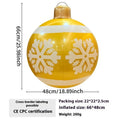 Large red inflatable Christmas ball with snowflake pattern and flash light, shown with a hand pump in a garden setting.