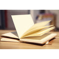 Kraft paper sketchbook with wireless binding open to a blank page