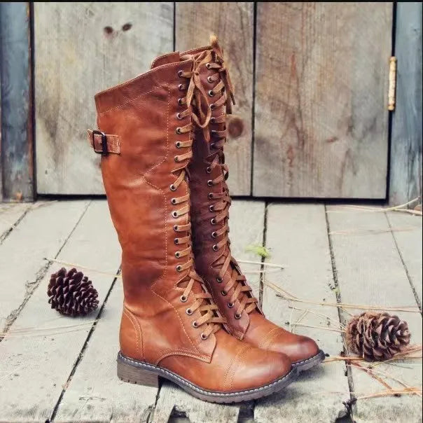 Black chunky heel high leg boots with a round toe and short stout heel on a plain background.