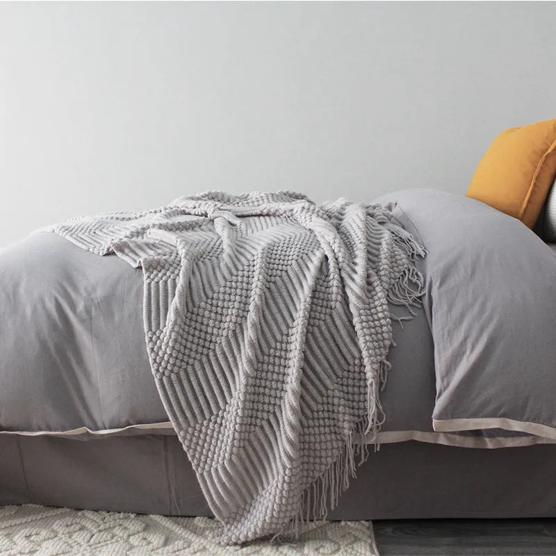 Small light grey polyester nap blanket folded, showing its 127cm by 170cm size.