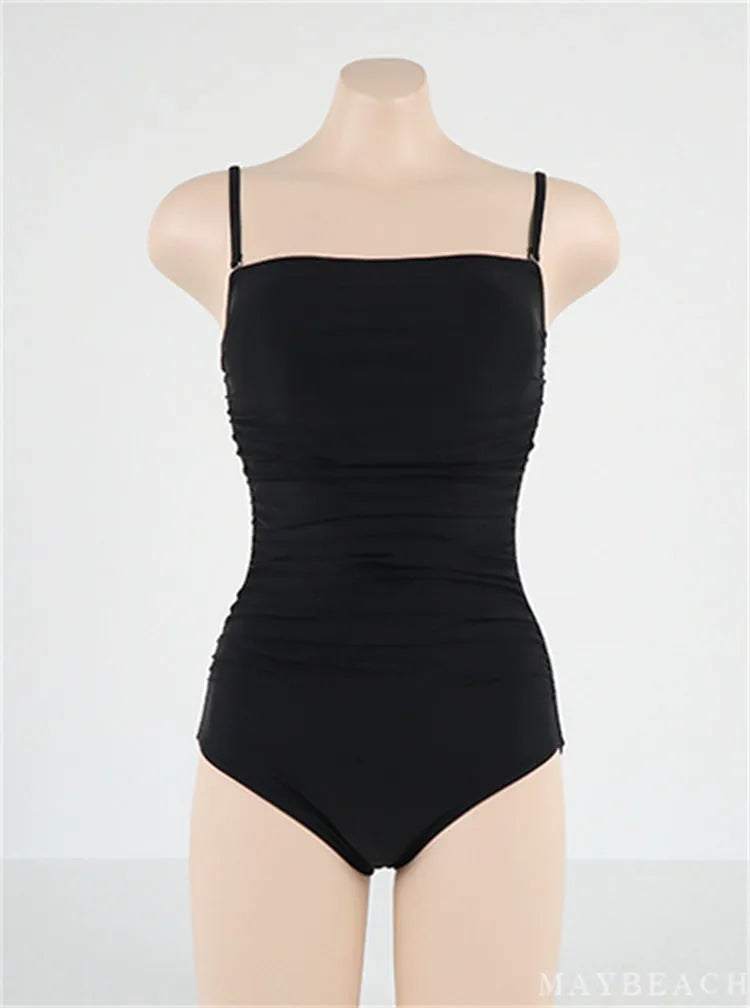 Blue sling style one-piece swimsuit with belly pleats on a mannequin, showing slim-fit design