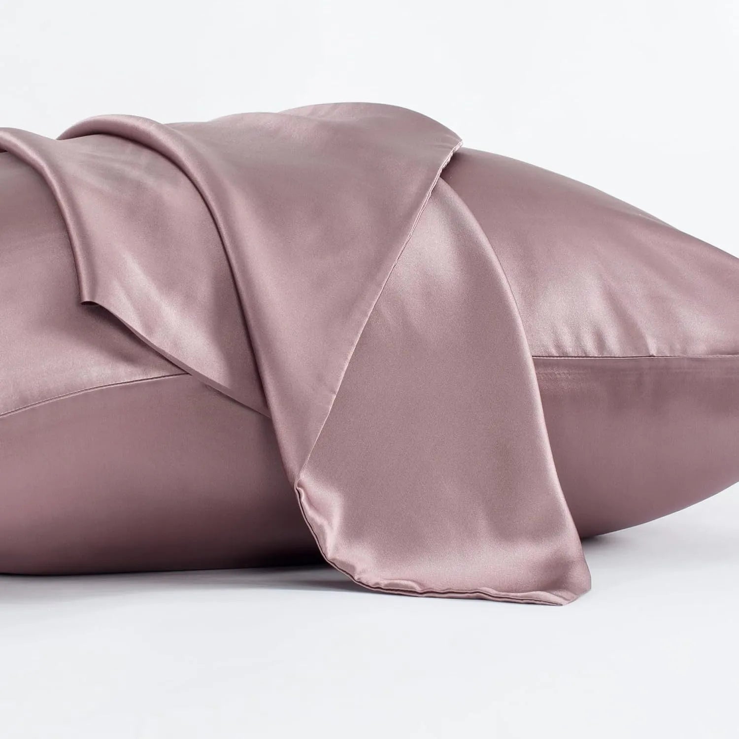 Dark grey mulberry silk pillowcase with an envelope closure on a bed.