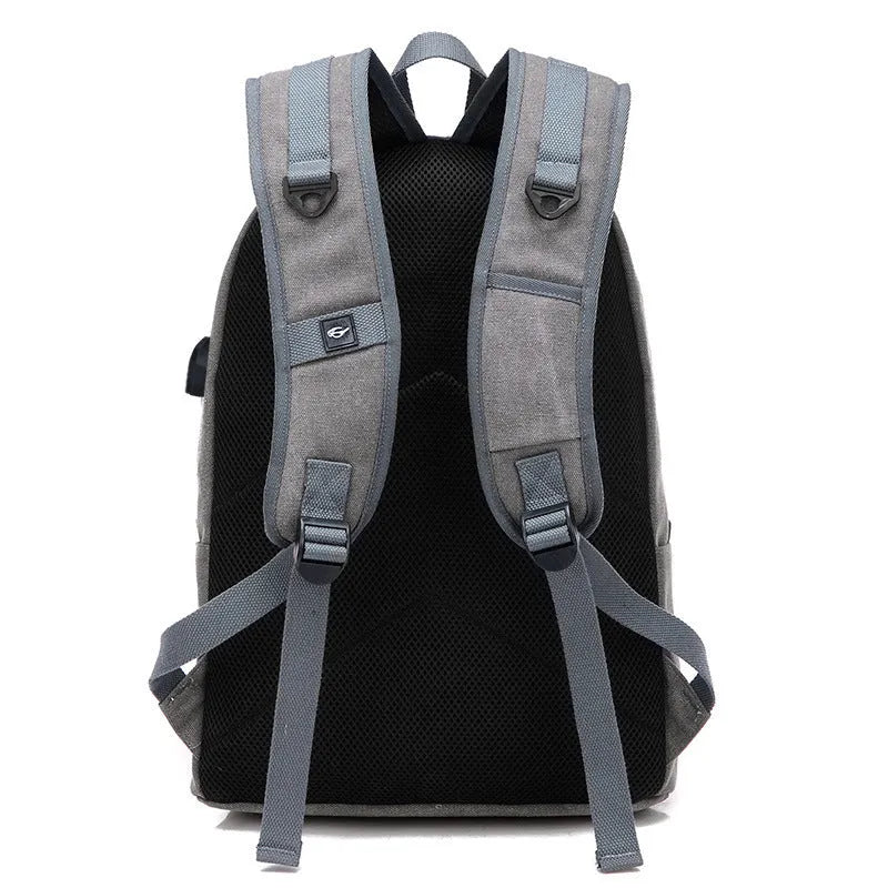 Canvas backpack with USB charging port showing multiple compartments including laptop section