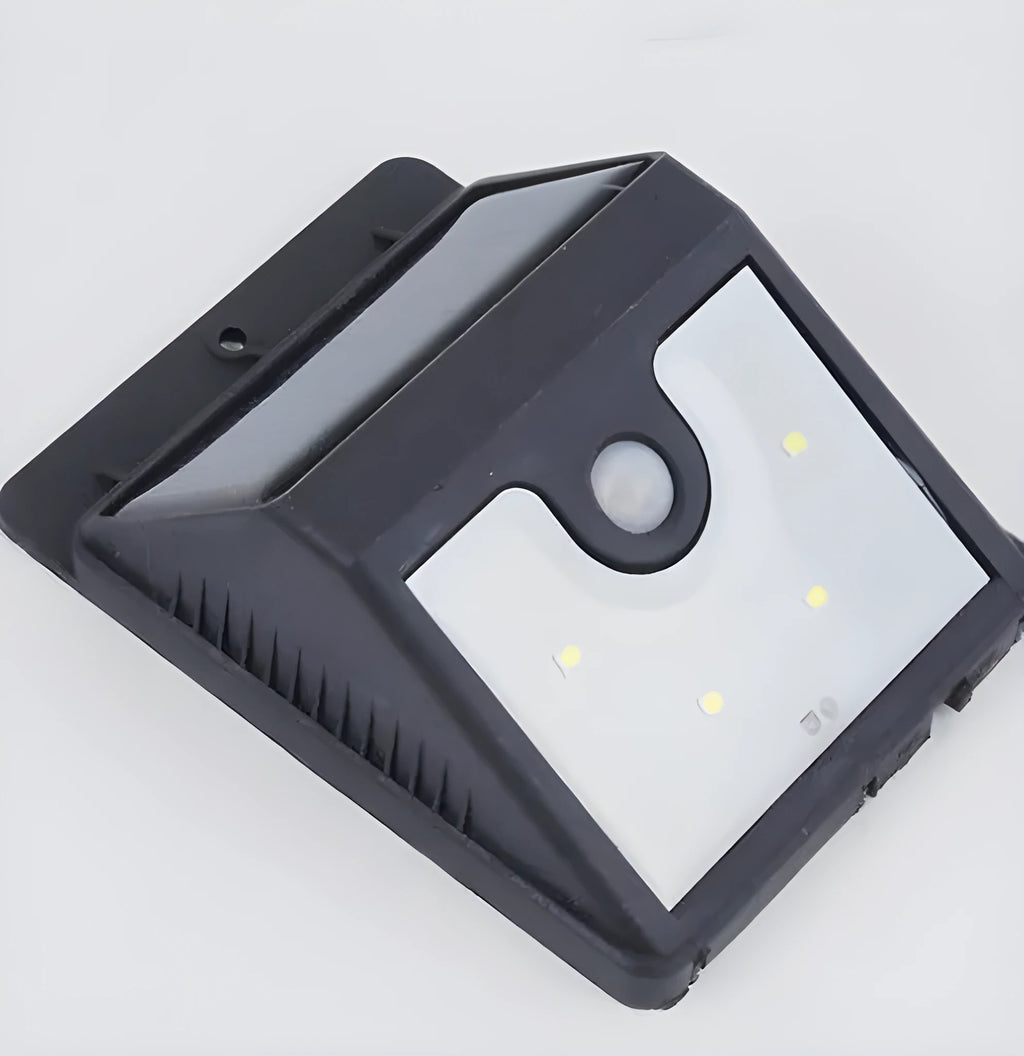 Set of four white solar-powered LED security lights with motion sensors mounted on an outdoor wall.