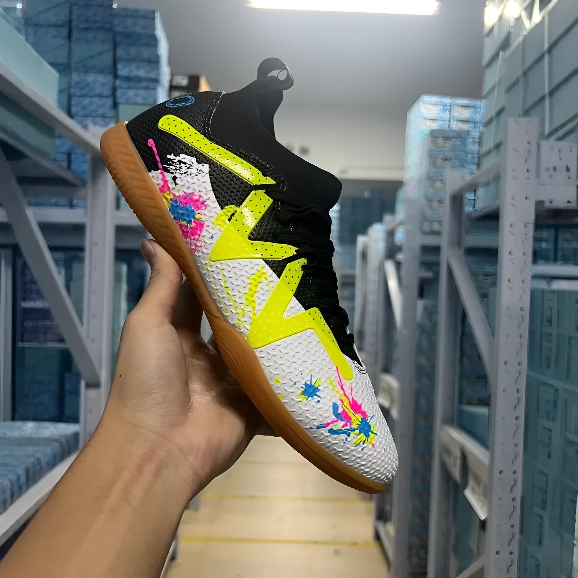 Low-top soccer shoes with broken spike nails on non-slip rubber outsole in black and yellow colourway