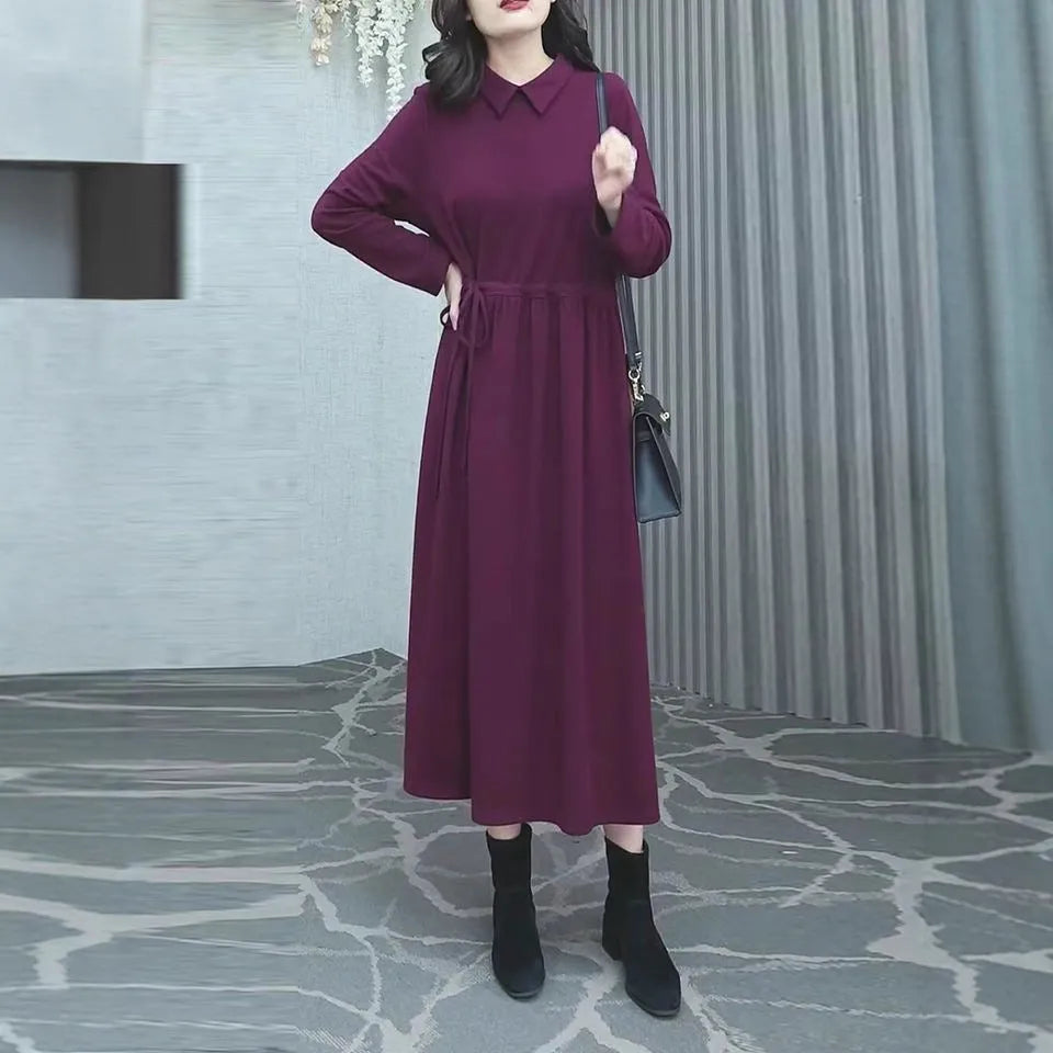 Purplish red plus size women's dress with long skirt and extra-long sleeves on a model.