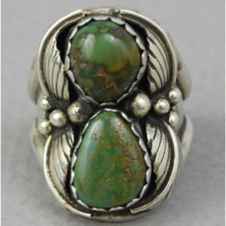 Silver-toned geometric women's ring with a turquoise stone inlay, shown on a finger.