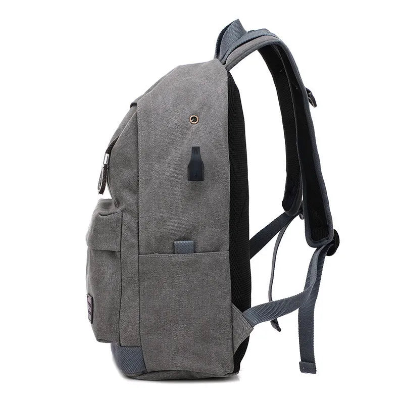 Canvas backpack with USB charging port showing multiple compartments including laptop section