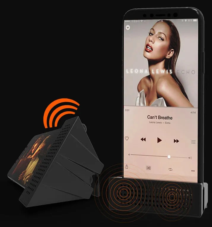 A portable black ABS plastic phone amplifier holder on a desktop, showing a mobile phone inserted for sound amplification.