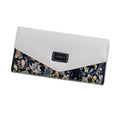 Women's black trifold leather wallet with buckle clip closure showing card slots and coin compartment
