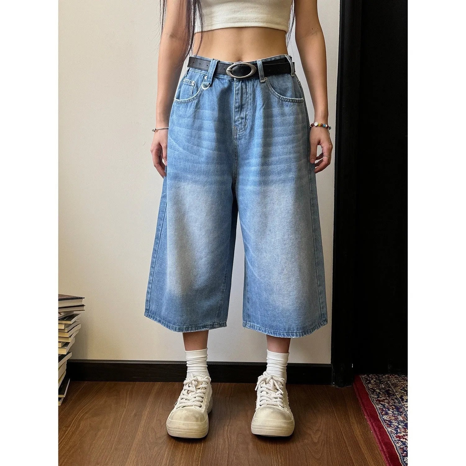Man wearing blue loose straight-leg denim shorts for summer.